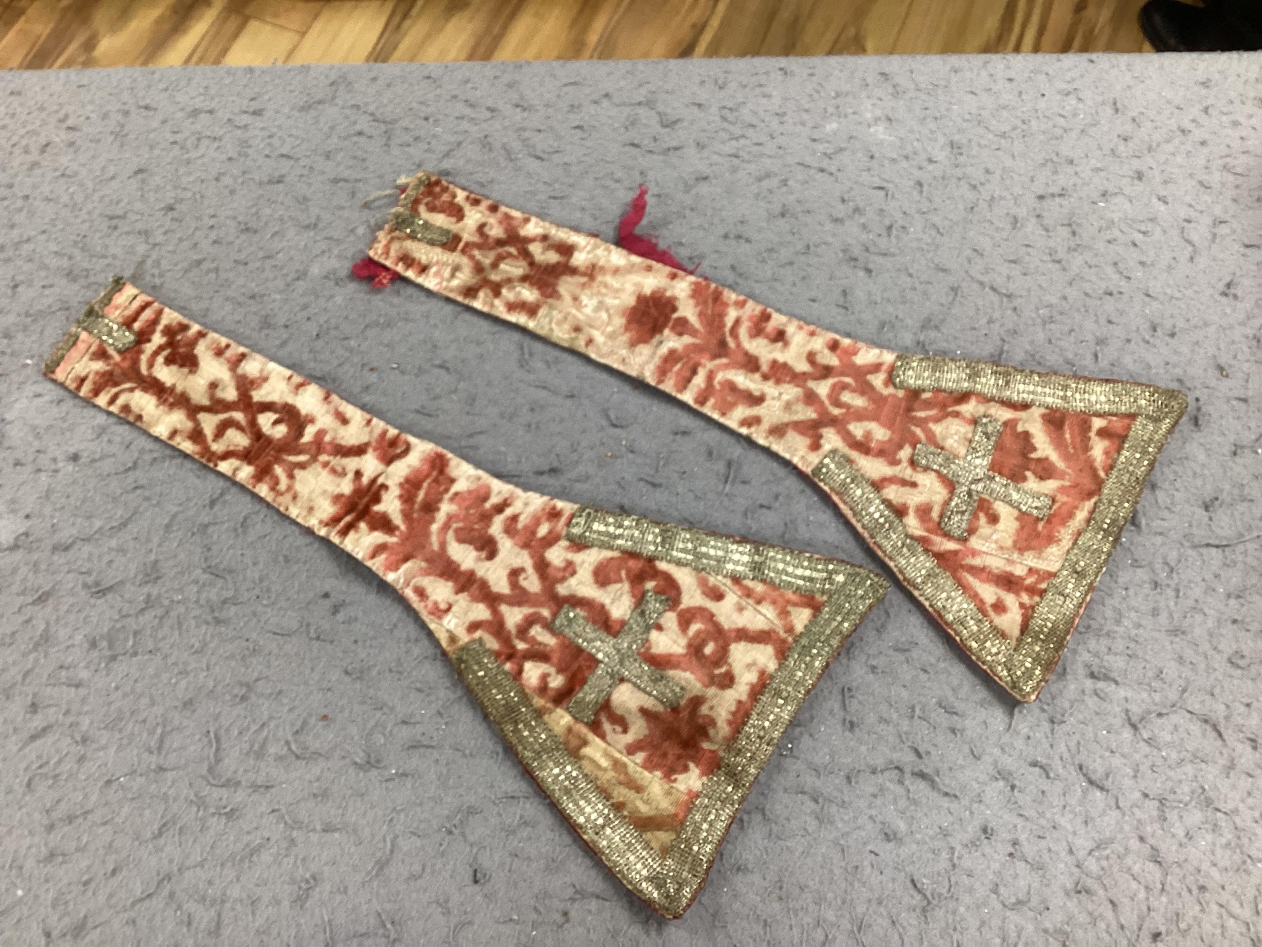 A collection of 18th and 19th century textiles, to include religious Maniples, two cushions, an embroidered chain stitch table cover with intricate edging, a Chinese embroidered panel and floral painted satin. Condition